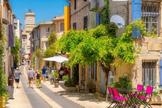 Une rue ensoleillée à Marseille bordée de charmants bâtiments, de verdure et de personnes appréciant l'atmosphère vibrante | MSC Cruises
