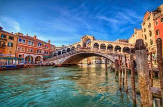 Le pont Rialto s'étend sur le Grand Canal à Venise, avec des bâtiments colorés et des gondoles se reflétant dans l'eau | MSC Croisières