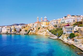 Charmanter Küstenblick auf Ermoupoli in Syros, Griechenland, mit bunten Gebäuden vor einem klaren blauen Himmel | MSC Cruises
