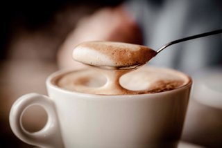 A warm cappuccino with frothy milk, enjoyed in a cozy coffee bar setting aboard MSC Preziosa | MSC Cruises