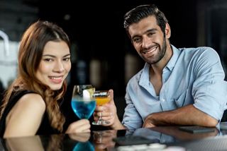 A couple enjoying vibrant beverages together at the piano bar on MSC Fantasia | MSC Cruises