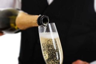 A waiter pours champagne into a flute, creating a festive atmosphere in the Top Sail Lounge on MSC Preziosa | MSC Cruises