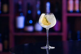 A refreshing gin tonic garnished with lemon and rosemary, served at Il Transatlantico Piano Bar | MSC Cruises