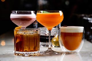 A selection of four vibrant cocktails arranged elegantly on a bar counter, inviting enjoyment and celebration | MSC Cruises