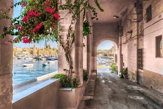 A charming archway adorned with flowers, leading to views of the Grand Harbour in Valletta, Malta | MSC Cruises