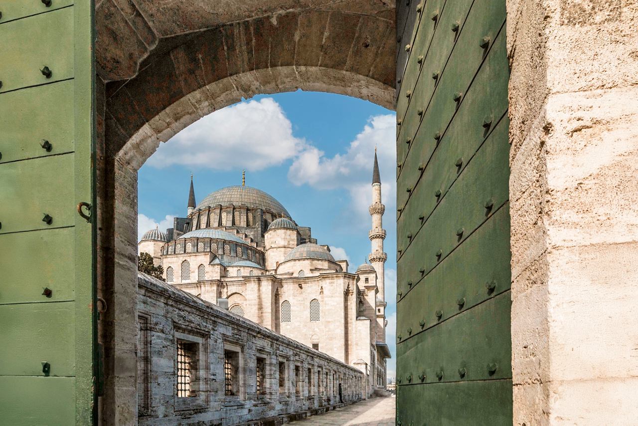 A view through a green archway revealing the stunning architecture of Istanbul's historic mosque | MSC Cruises