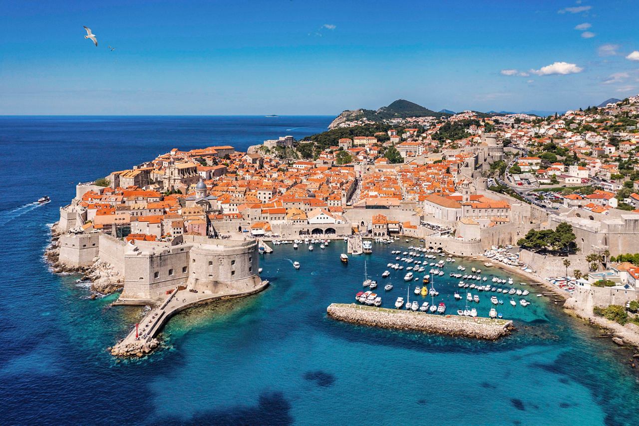 Aerial view of Dubrovnik's picturesque coastline with vibrant buildings and clear blue waters | MSC Cruises