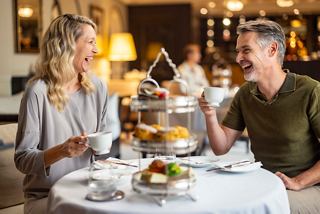 A couple enjoys a delightful beverage together at a beautifully set table in a warm, inviting setting | MSC Cruises