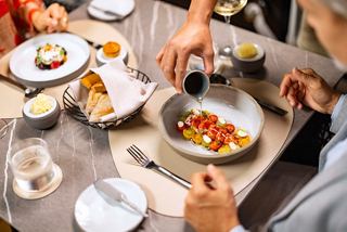 Una pareja disfrutando de una comida en una mesa bellamente decorada con un personal atento | MSC Cruceros