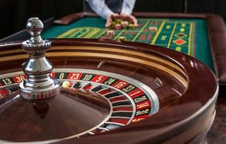 A roulette table with vibrant colours and a dealer preparing for the next game | MSC Cruises