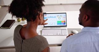 A couple engaging with a computer to explore internet options on board their MSC cruise | MSC Cruises