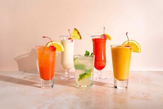 Eine Auswahl an lebhaften alkoholfreien Cocktails, garniert mit Obst, serviert in eleganten Gläsern | MSC Cruises