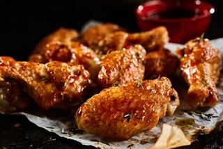 A delicious platter of crispy chicken wings served with a small bowl of dipping sauce | MSC Cruises