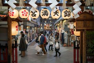 A bustling market scene in Kyoto, Japan, filled with people enjoying local food and vibrant lanterns | MSC Cruises