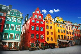 Des bâtiments vibrants de diverses couleurs bordent la rue, mettant en valeur l'architecture charmante de Stockholm | MSC Croisières
