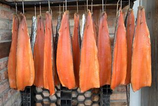 Cured salmon fillets hanging in a traditional setting, showcasing culinary artistry in Oslo, Norway | MSC Cruises