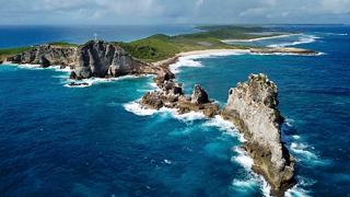 A stunning coastal view of Guadeloupe featuring rocky formations and vibrant blue sea | MSC Cruises