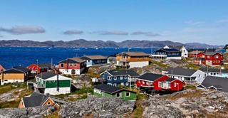 Une vue vibrante de maisons colorées à Nuuk, Groenland, avec un ciel clair et la mer en arrière-plan | MSC Croisières