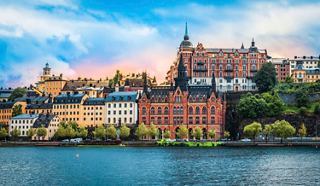 Une vue vibrante de bâtiments colorés le long du waterfront à Stockholm, en Suède, sous un ciel bleu lumineux | MSC Croisières