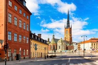 Rues charmantes de Stockholm avec des bâtiments historiques et un haut clocher sous un ciel bleu vif | MSC Croisières