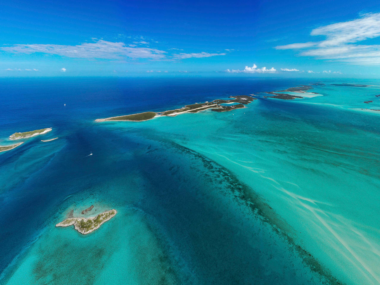 A breathtaking aerial view of Great Exuma Island showcasing the vibrant sea and lush vegetation under a clear sky | MSC Cruises
