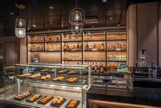 A stylish bar counter filled with pastries and beverages at the Coffee Emporium on MSC World Asia | MSC Cruises