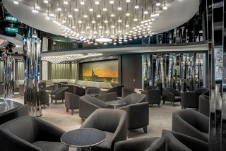A stylish lounge area with comfortable seating, vibrant artwork, and a welcoming atmosphere at the Dolce Vita Bar | MSC Cruises