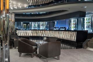 A stylish bar area with comfortable seating, elegant counter, and a welcoming atmosphere aboard MSC World Asia | MSC Cruises