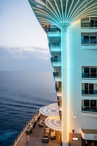 A stunning view of the MSC World Asia's balcony area, showcasing palm tree lights and the sea in the background | MSC Cruises