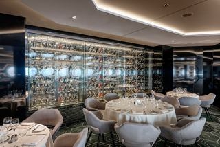 A beautifully arranged dining area in the Esagono - Hexagon Restaurant with elegant tables and a stunning glass wall | MSC Cruises