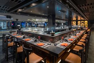 A spacious dining area featuring a long table set for guests at Kaito Sushi Bar onboard MSC World Asia | MSC Cruises