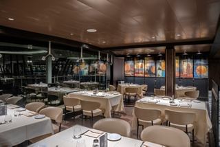 A warm and inviting dining area set up for guests at La Brasserie Buffet, featuring elegant tables and chairs | MSC Cruises