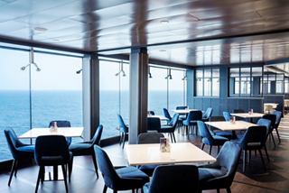 A panoramic view of the La Brasserie Buffet restaurant with tables and chairs overlooking the sea and sky | MSC Cruises