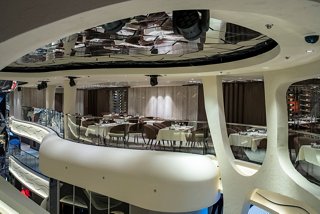 A stylish dining area in Les Dunes Restaurant featuring elegant tables and chairs for guests to enjoy their meals | MSC Cruises