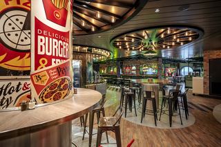 A vibrant specialty restaurant featuring a modern design with tables and a porthole view | MSC Cruises
