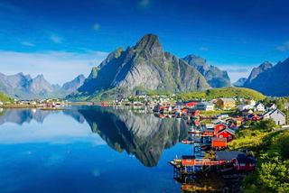 Scenic view of a tranquil lake reflecting mountains and colourful houses in Leknes, Norway | MSC Cruises