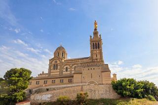 The iconic Notre-Dame de la Garde basilica stands proudly against a clear blue sky in Marseille, France | MSC Cruises