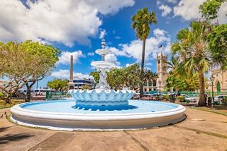 Ein schöner Brunnen, umgeben von Palmen und lebendigem Grün in Bridgetown, Barbados | MSC Cruises