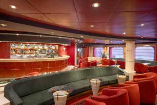 A welcoming lounge area featuring comfortable seating and a stylish bar, inviting relaxation and socialising | MSC Cruises