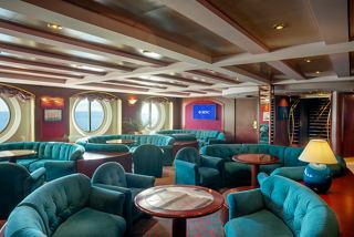 A cosy lounge area featuring plush seating and a welcoming atmosphere with a view of the sea | MSC Cruises