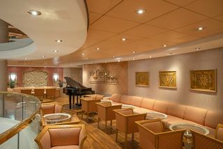 A welcoming lounge area with comfortable seating and a piano, perfect for relaxation and socialising | MSC Cruises