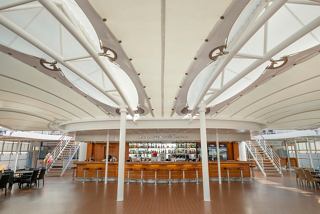 A spacious and inviting lounge area with modern seating and light-filled design for relaxation on MSC Lirica | MSC Cruises