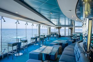 A vibrant lounge area with comfortable seating and stunning sea views, perfect for relaxation and entertainment | MSC Cruises