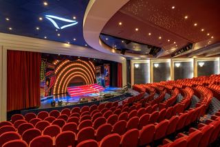 Un teatro espacioso con asientos rojos y un escenario, perfecto para disfrutar de actuaciones en vivo en MSC Lirica | MSC Cruceros