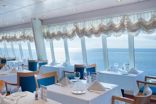 A bright restaurant with elegant seating and panoramic sea views invites guests to enjoy exquisite dining experiences | MSC Cruises