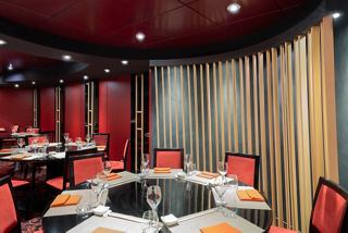 A stylish dining area with a round table surrounded by vibrant chairs, reflecting the inviting atmosphere of Kaito Sushi Bar | MSC Cruises
