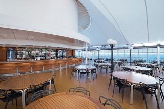 Elegant dining area in La Pergola with chairs and tables, offering stunning views of the sea | MSC Cruises