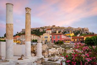 Antike Ruinen mit lebhaften Gebäuden und üppigen Blumen vor einem Sonnenuntergangshimmel in Athen, Griechenland | MSC Cruises