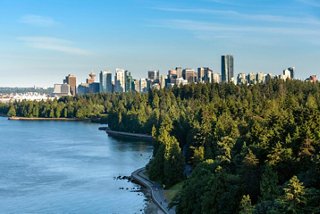 Ein malerischer Blick auf die Skyline von Vancouver, umrahmt von üppigen Bäumen und dem Meer | MSC Cruises