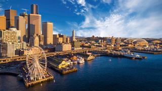 Die Skyline von Seattle bei Sonnenuntergang zeigt beeindruckende Architektur und Wolkenkratzer, die sich im Wasser spiegeln | MSC Cruises